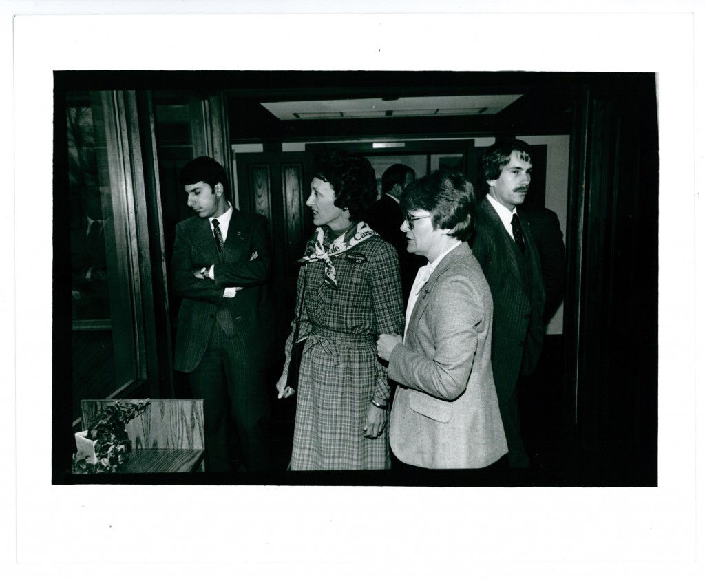Jan Warner (right) providing a tour of the Weyerhaeuser Museum for Joan Mondale (center), wife of U.S. Vice President Walter Mondale. The men surrounding them are agents of the Secret Service. October 15, 1980. #1981.3.3.