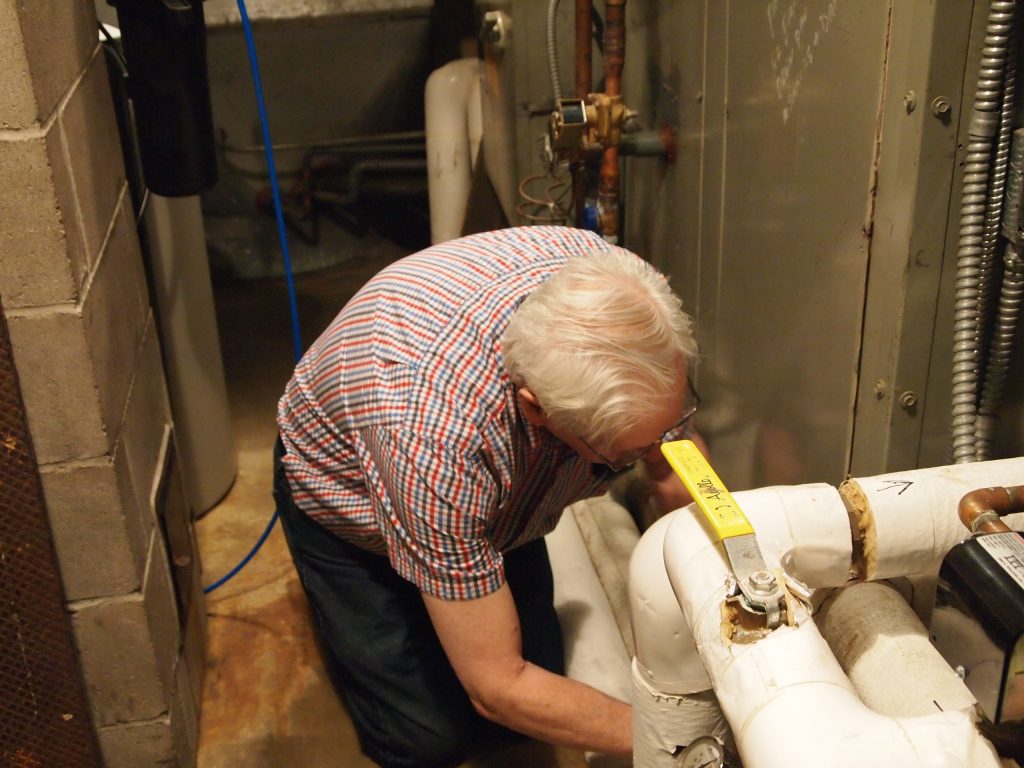 Art Warner removing a panel to access the cooling coil on the furnace at The Charles A. Weyerhaeuser Memorial Museum, Little Falls, MN, February 15, 2013.