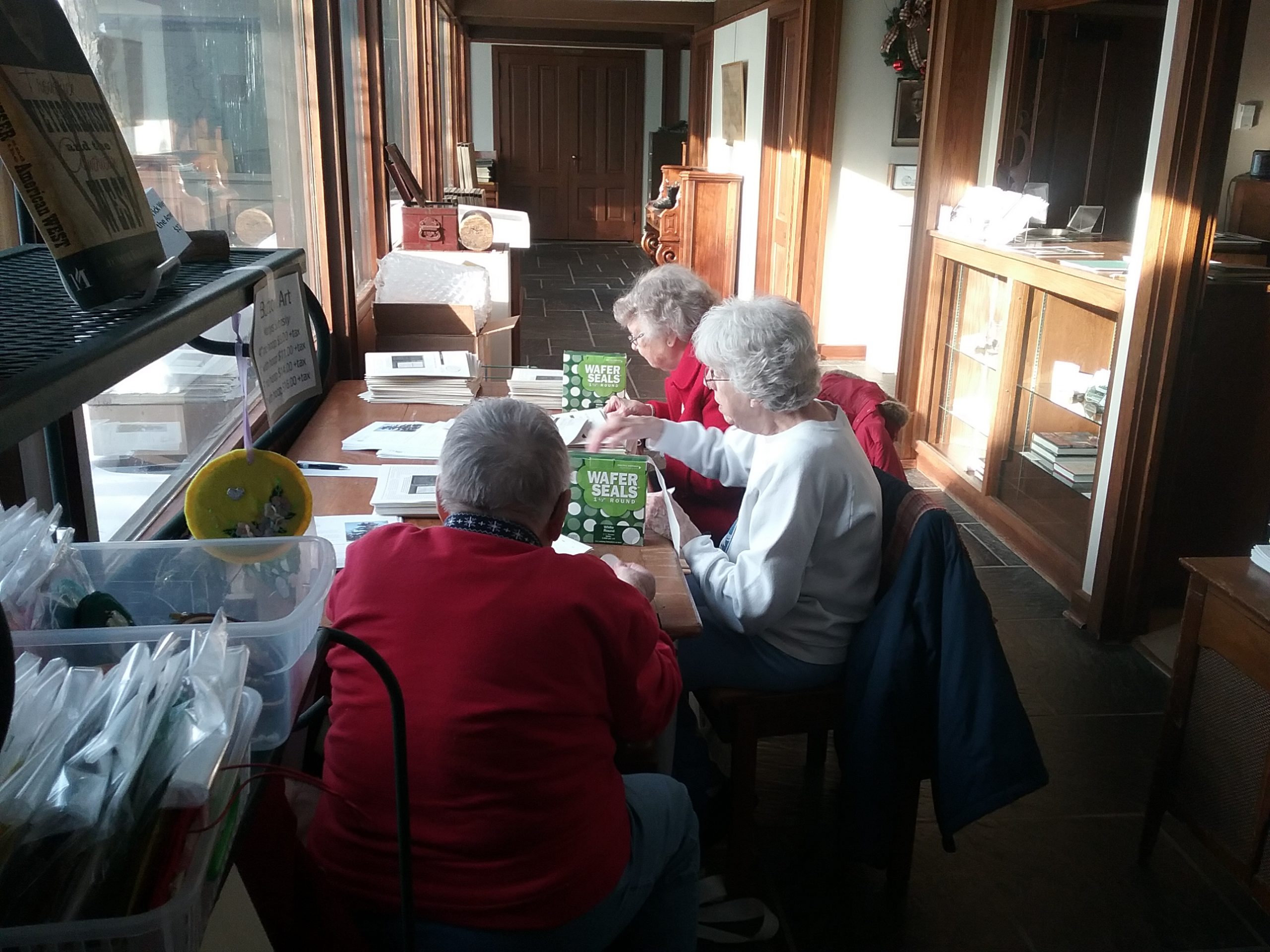 The Weyerhaeuser Museum's A-Team, Alvina, Alice, and Ardyce, folding newsletters, December 21, 2019.