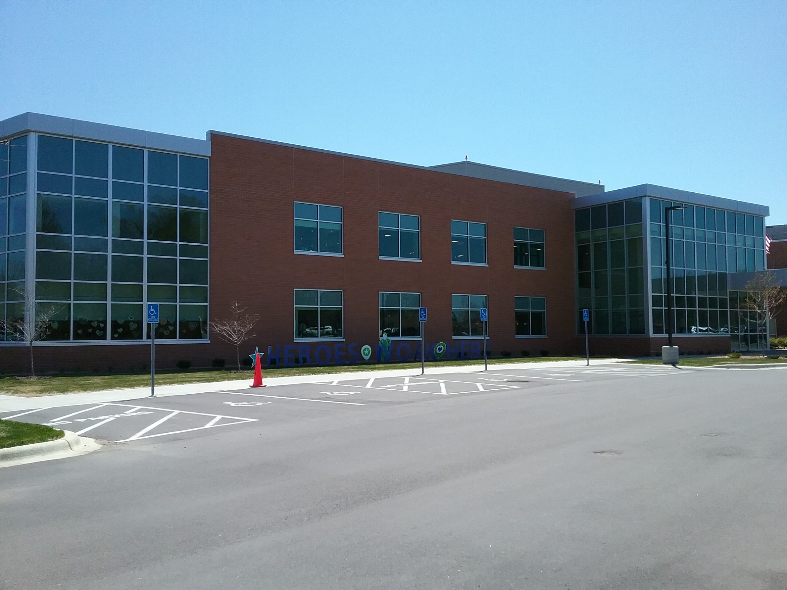 "Heroes Work Here" sign in blue letters against a west exterior wall of St. Gabriel's Hospital, Little Falls, MN, May 11, 2020.