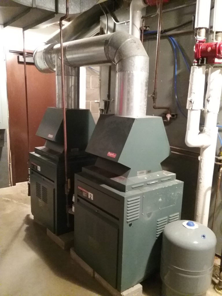 Gas boilers in front of air handler in the furnace room at The Charles A. Weyerhaeuser Memorial Museum, Little Falls, MN. This system was originally installed when the museum was built in 1974/75, with the gas boilers being an upgrade in the 1990s. Photo taken October 2, 2021.